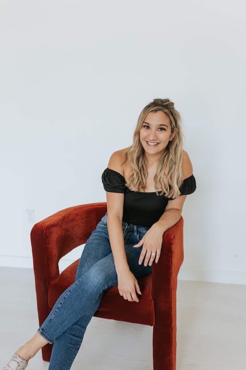 Dr. Lahana Vigliano seated in a red chair